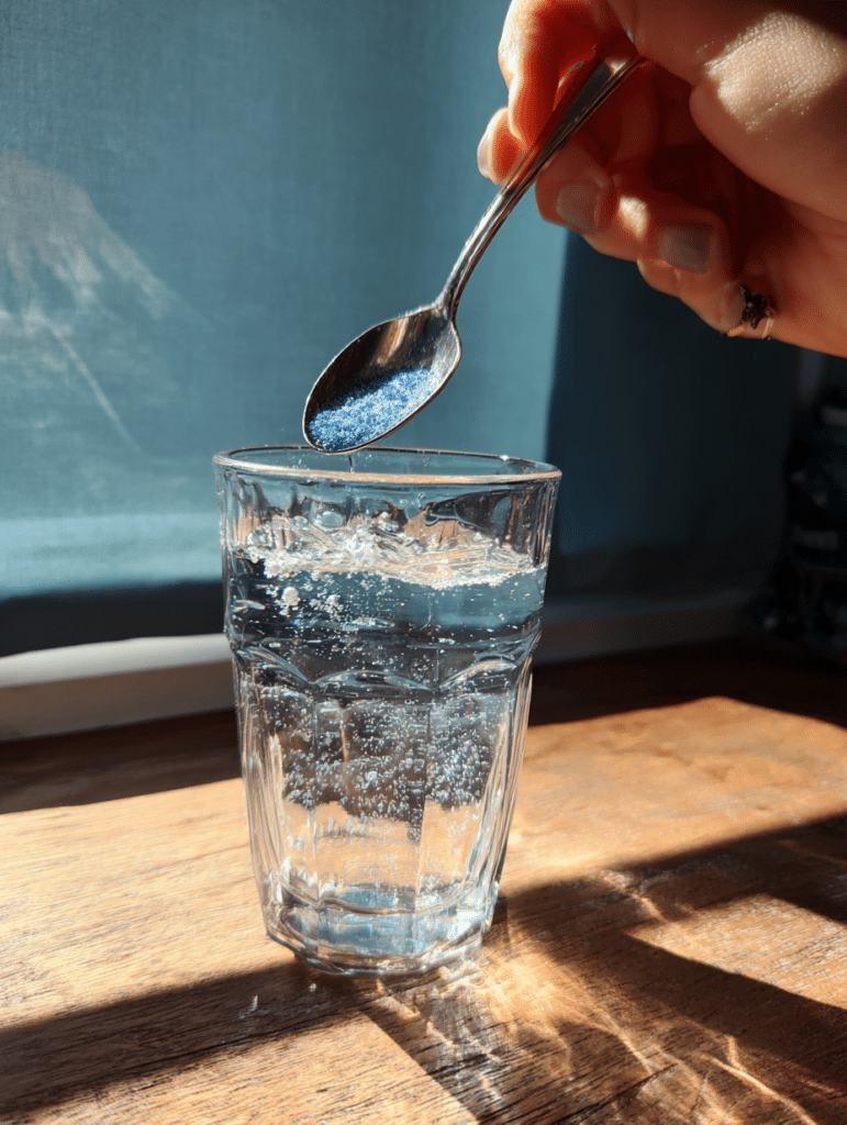 mixing blue salt trick recipe in glass of water